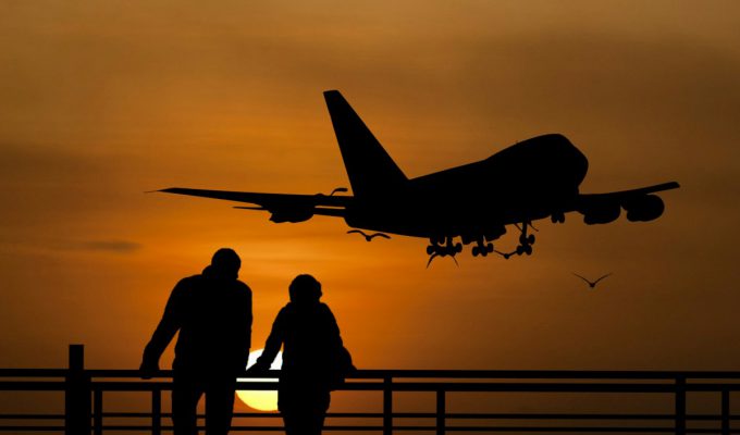Silhouettes of people watching plane take off